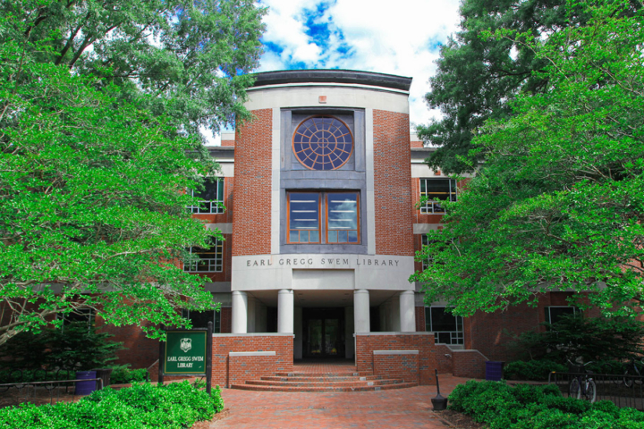 Green tree limbs surround the entrance to Swem Library.