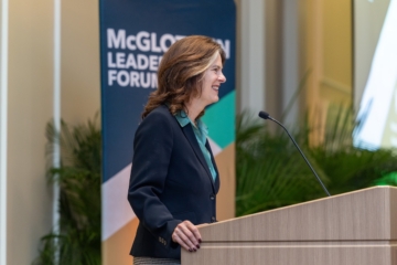 Katherine Rowe smiles while standing at a podium.