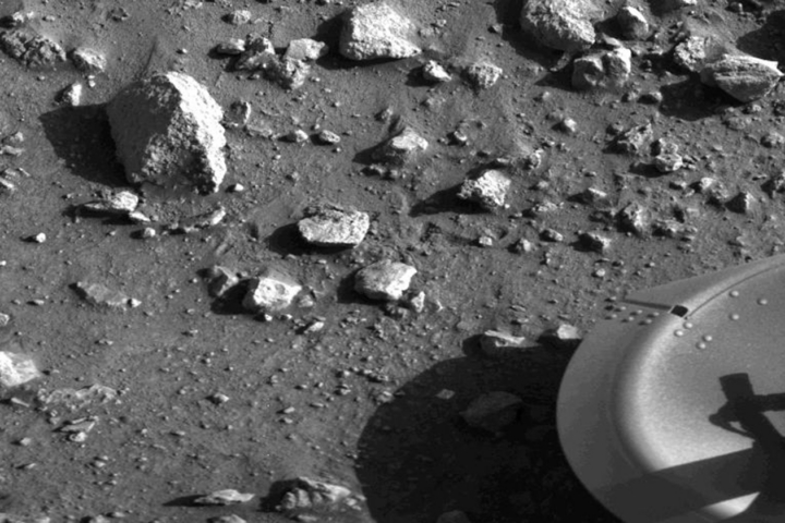 A black and white image shows rocks on the surface of Mars.