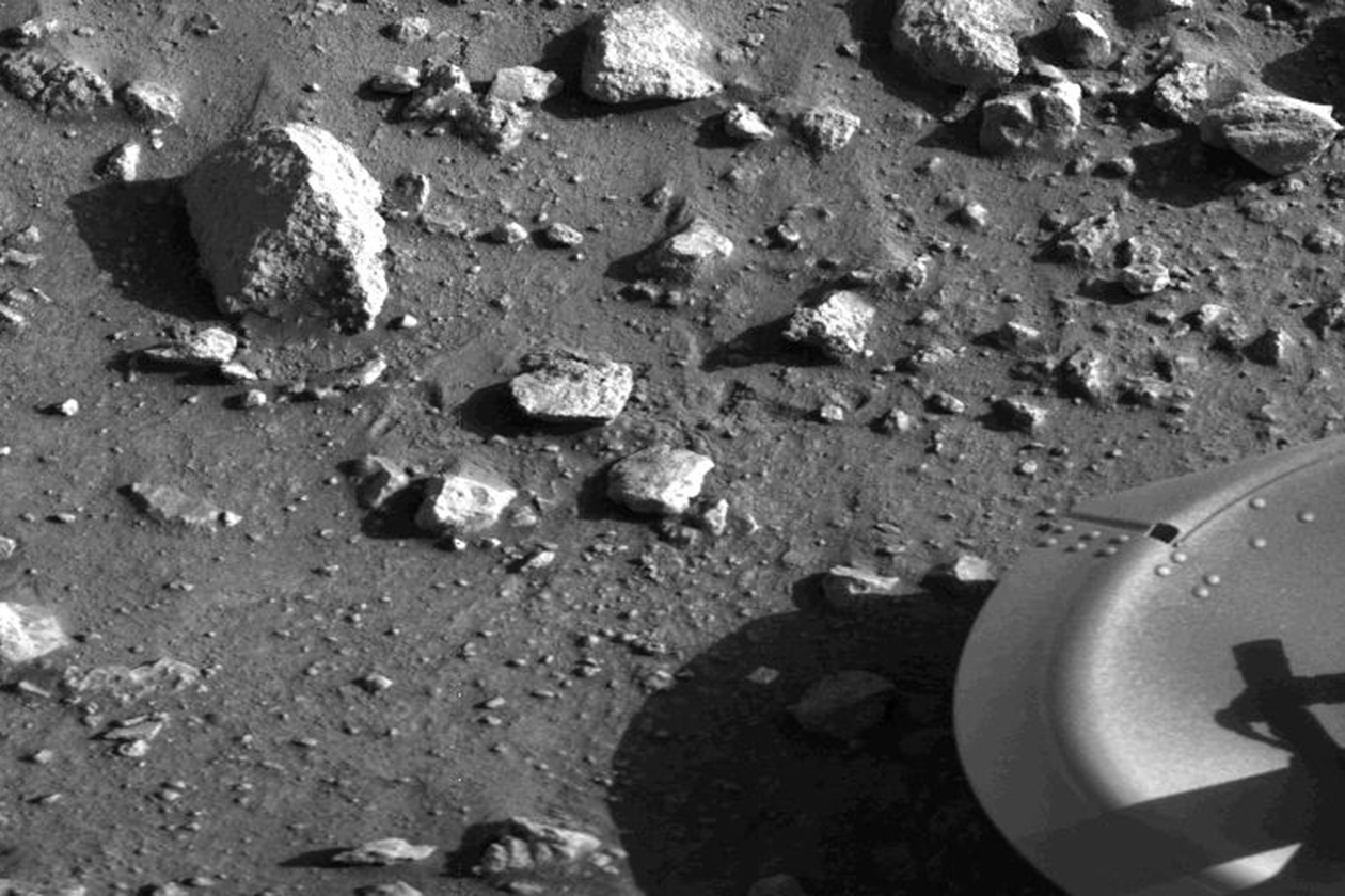 A black and white image shows rocks on the surface of Mars.