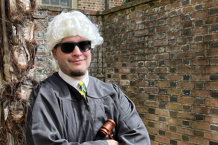 Assistant Dean Trey Mayo Ed.D. ’22 wears a judge's wig and academic robe.