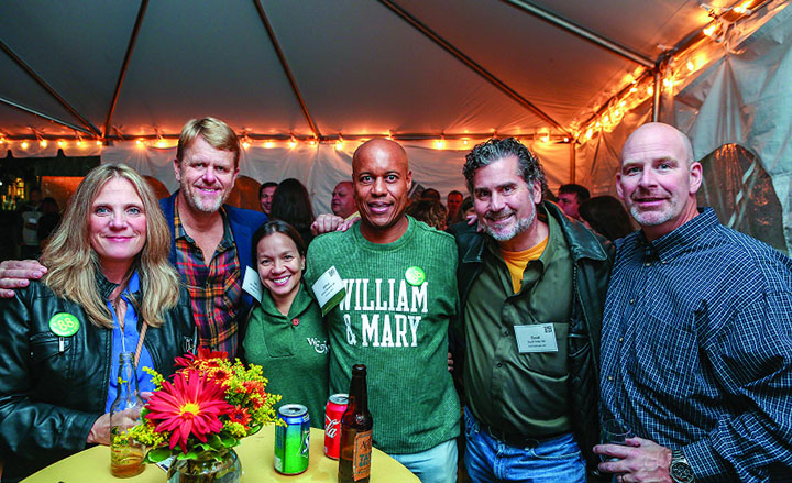People pose for a photo together under a tent.
