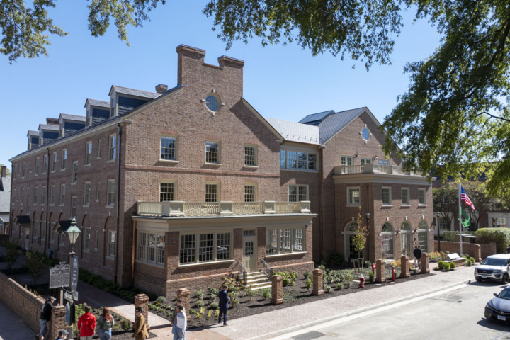 The exterior of a brick building with an American flag out front.