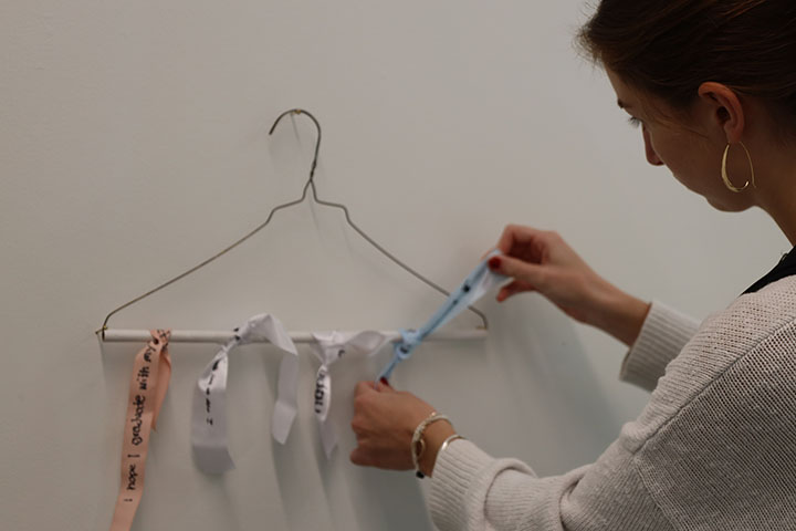 A person ties a ribbon onto a hangar.