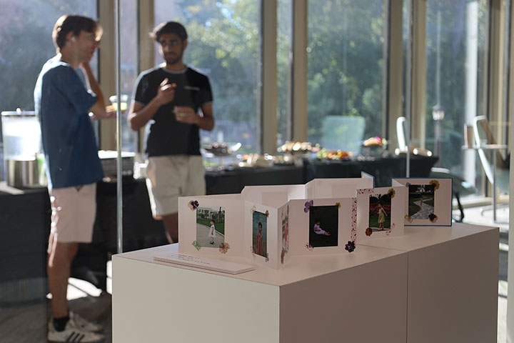 People chat near an art display.