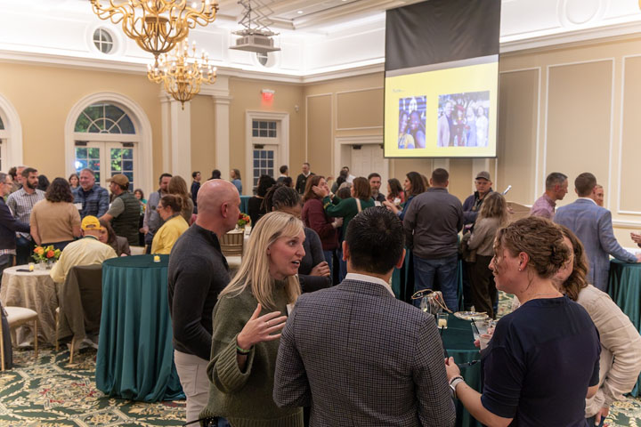 People mingle and chat in a large room.