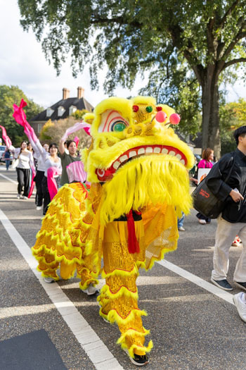 People wear a dragon costume in a parade.