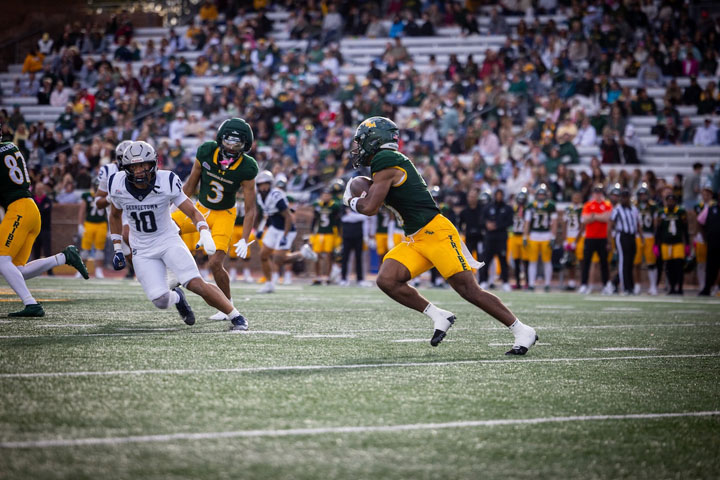 A football player runs down the field.
