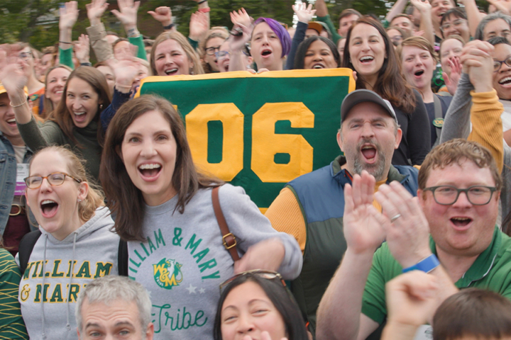 People cheer while holding an '06 flag.